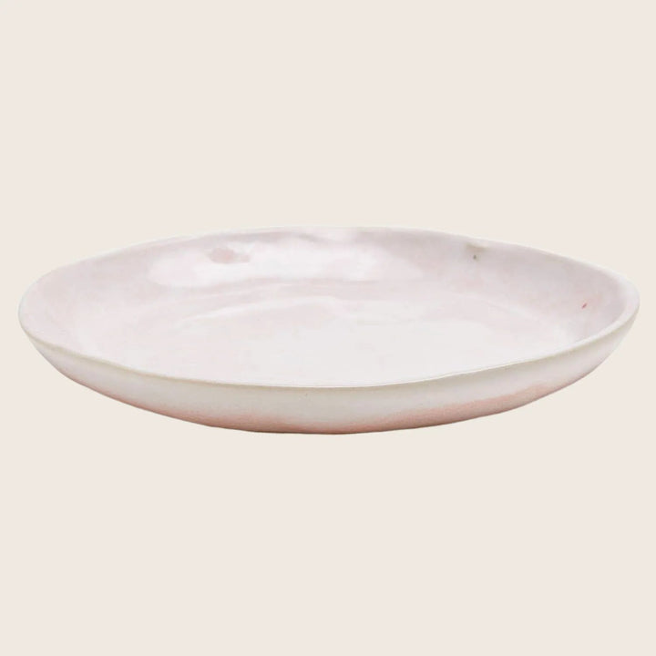 Simple oval ceramic plate with gentle curve and glossy finish.