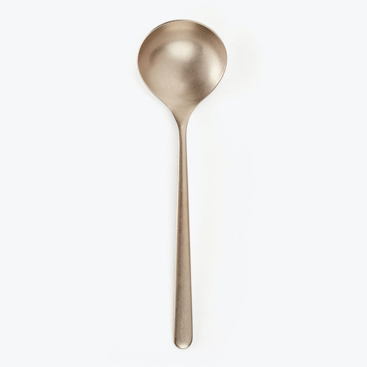 Single stainless steel spoon with long handle on plain background.
