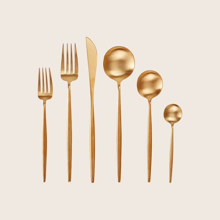Set of six modern gold utensils for formal dining setting.