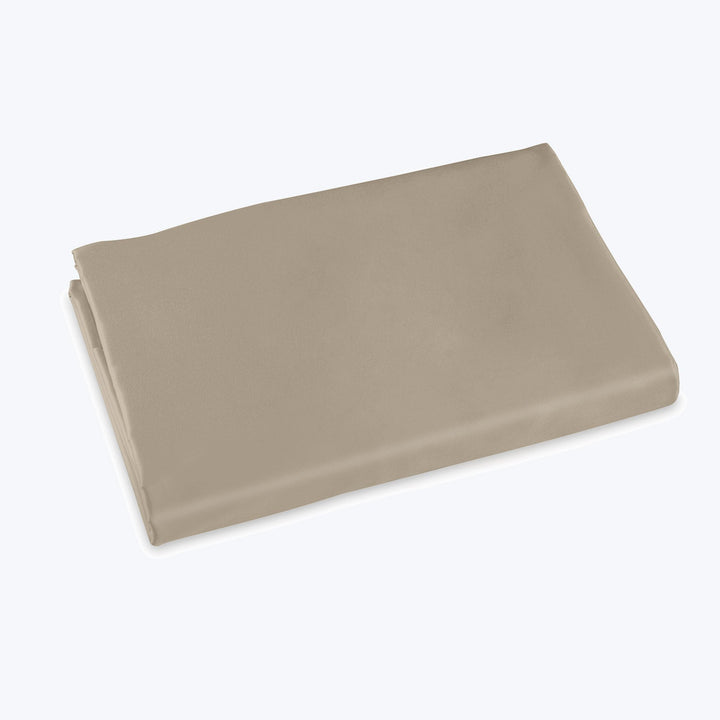 Neatly folded beige fabric with smooth texture on flat surface.