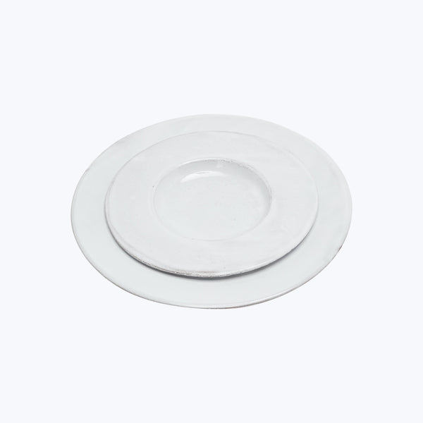 Modern white ceramic plates stacked, minimalistic dining setting concept.