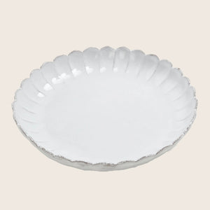White ceramic plate with scalloped edge adds elegance to dining. - hover