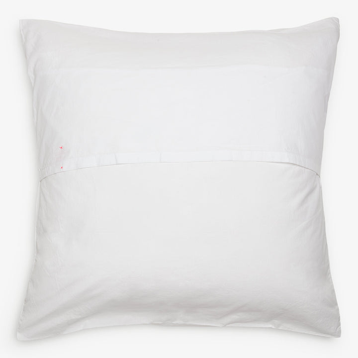 Soft white pillow with red stains on one side. Comforting simplicity.