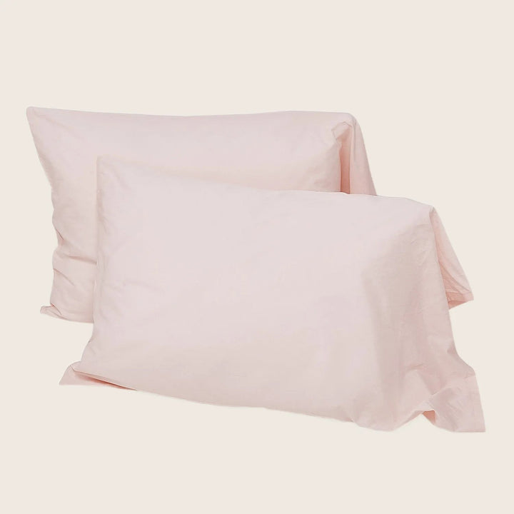 Pair of square pink pillowcases on white background. Soft texture.