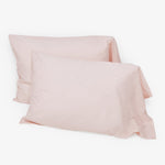 Pair of square pink pillowcases on white background. Soft texture.