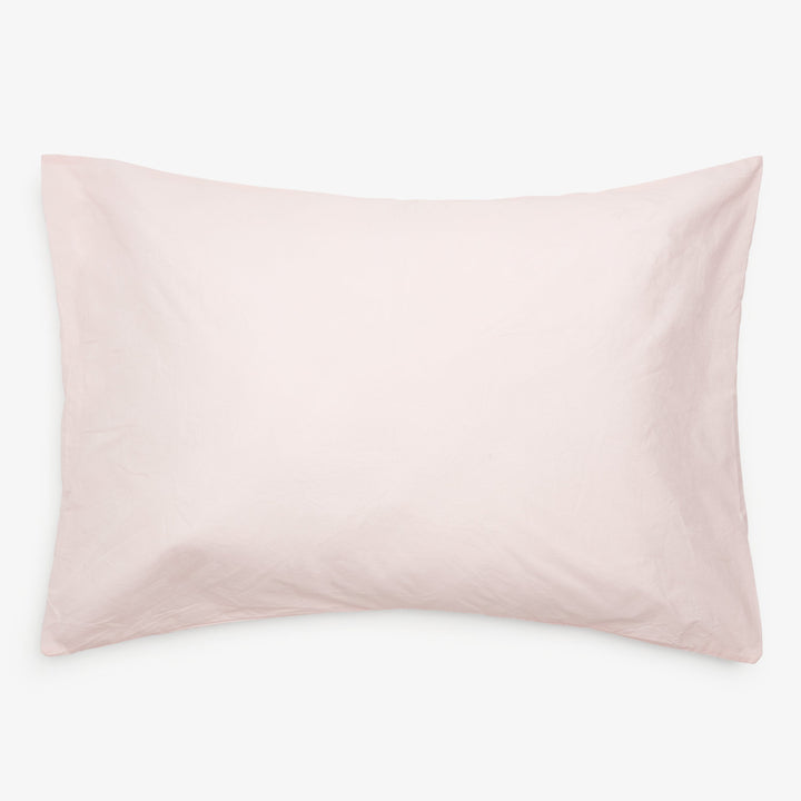 Soft rectangular pillow with light pink pillowcase on white background.