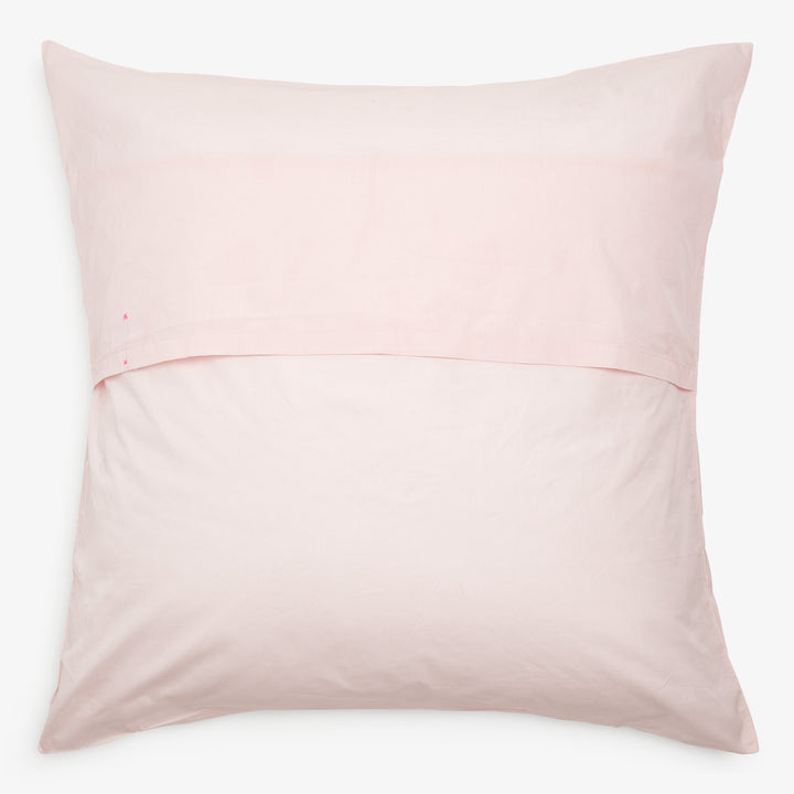 Light pink pillowcase with visible seam and small red dot.