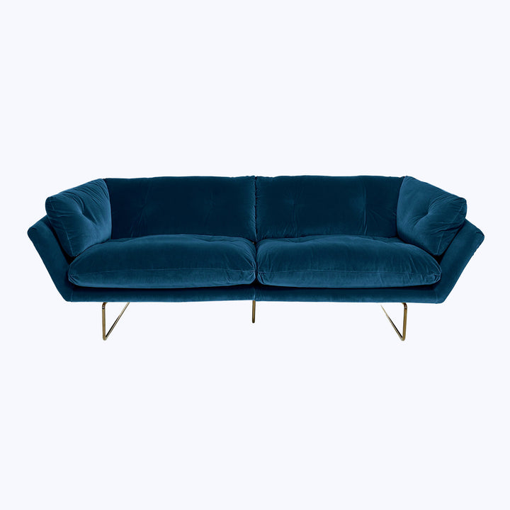 Modern blue velvet sofa with sleek design and metallic legs.