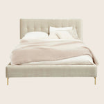 Contemporary bed with upholstered headboard and elegant metal legs.