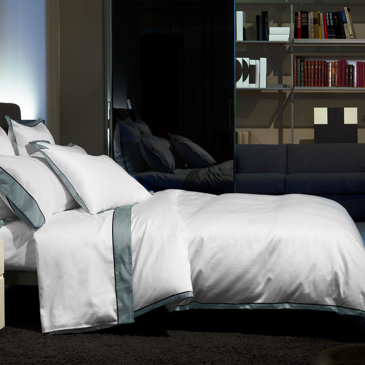 Modern bedroom with white bedding, dark accents, and stylish decor.