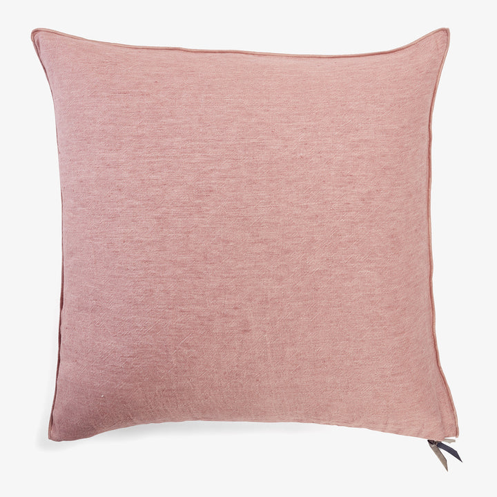 Square pink cushion with textured fabric and piped edges.