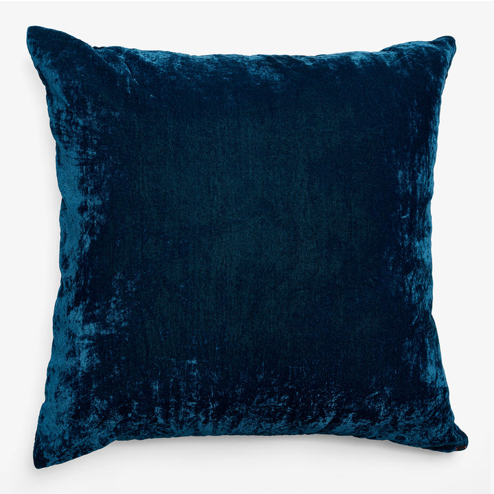 Luxurious deep blue velvet cushion on clean white background.