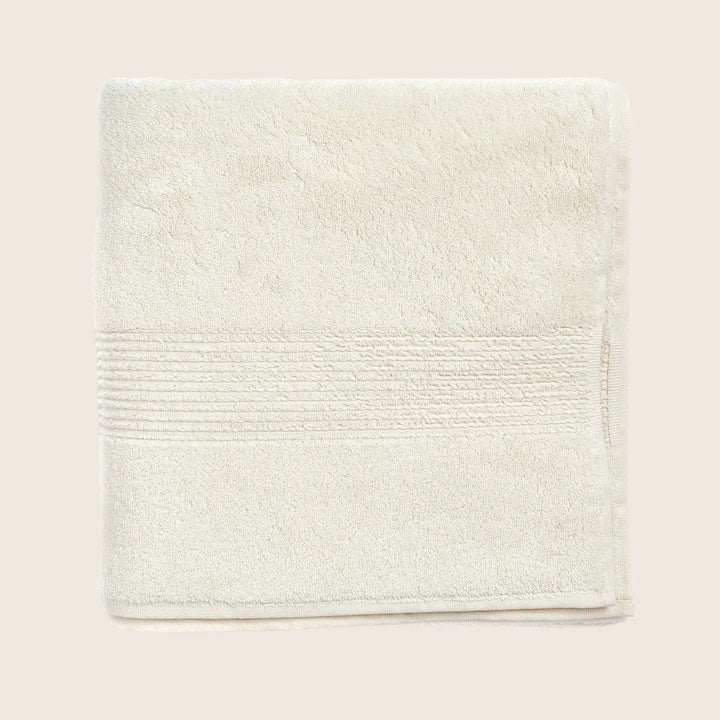 Soft, fluffy towel with textured band on white background.
