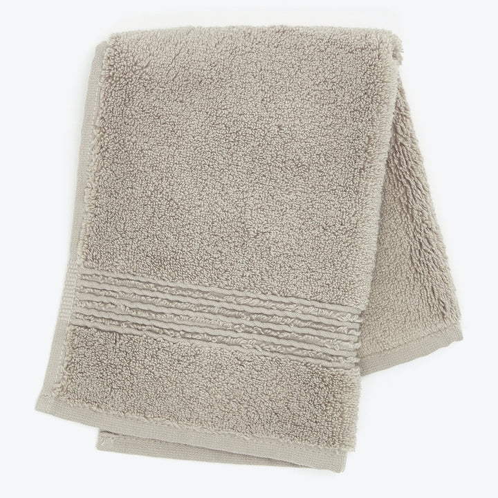 Soft, absorbent folded bath towel in light beige color, textured.