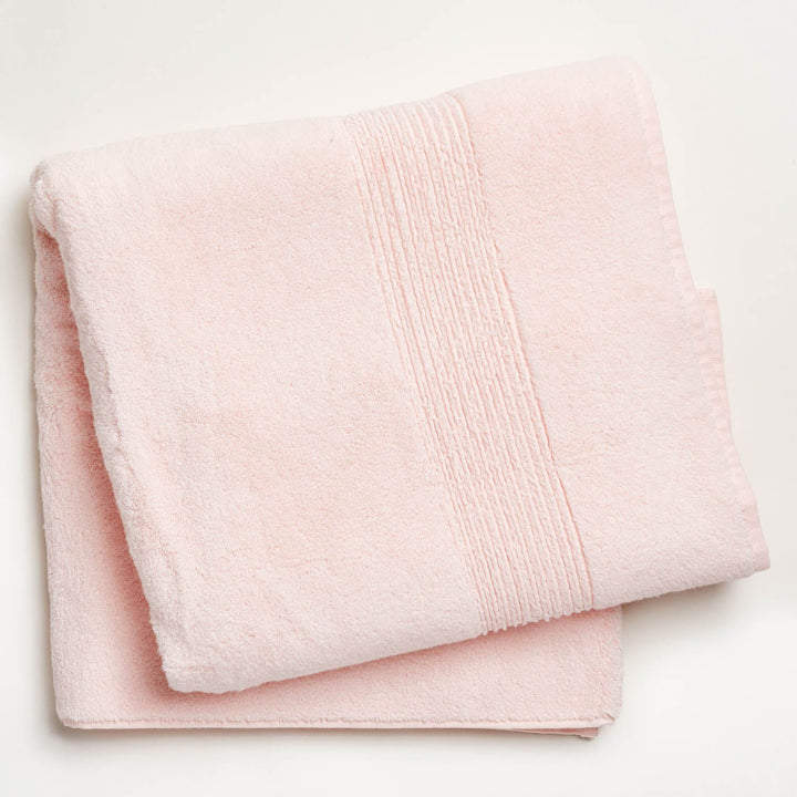 Soft, fluffy light pink bath towel with decorative ribbed border