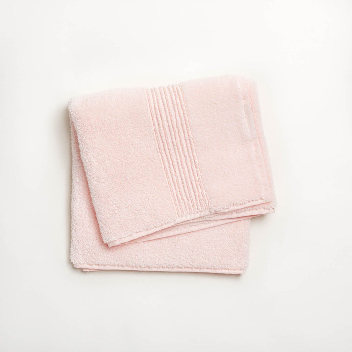 Soft pink bath towel with textured pattern and decorative stripes.
