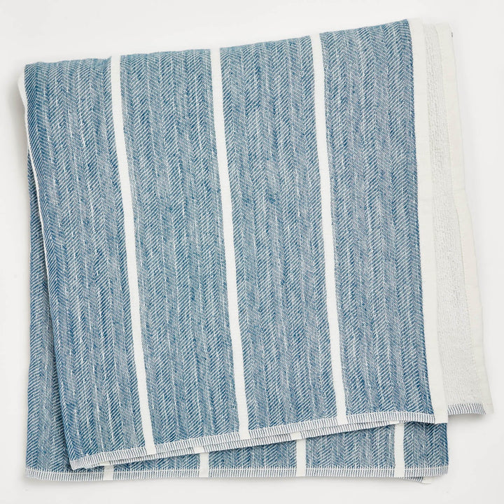 Blue and white herringbone patterned kitchen towel with neat hemming.