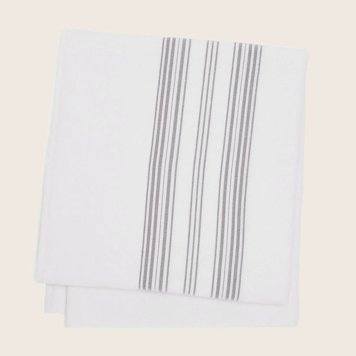 Freshly folded white kitchen towel with modern gray stripes design.