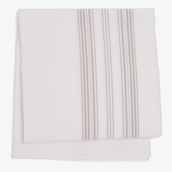 Neatly folded cloth with vertical stripe pattern on white background.