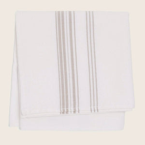 Neatly folded white towel with vertical stripe design in tan