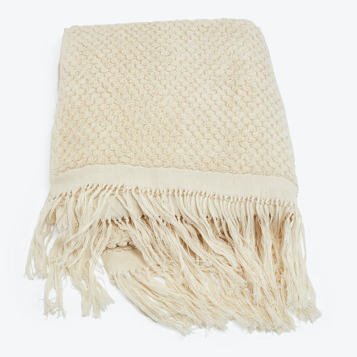 Cozy cream throw blanket with textured knit design and fringe