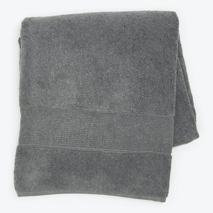 Folded gray terrycloth bath towel with decorative band on top