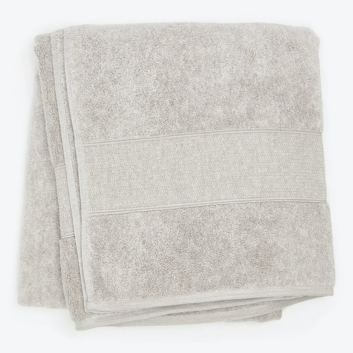 Soft and absorbent light grey bath towel with decorative bands.