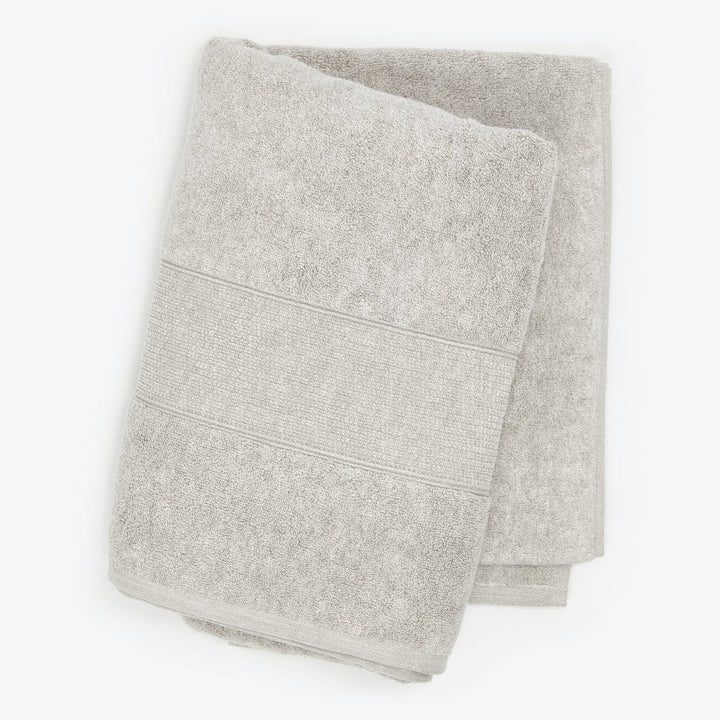 Neatly folded light grey towels with plush terry cloth texture