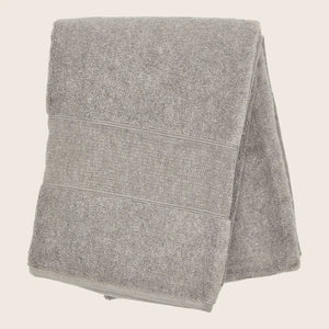 Soft white bath towel with decorative band on white background. - hover