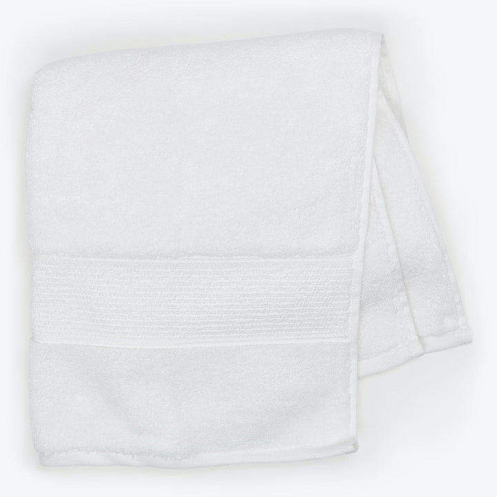 Soft and fluffy white bath towel with decorative textured band.