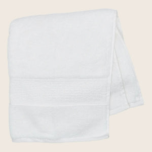 Two soft, plush bath towels with decorative trim on top. - hover