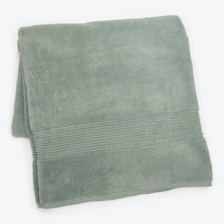 Soft sage green bath towel with decorative ribbed band detail.
