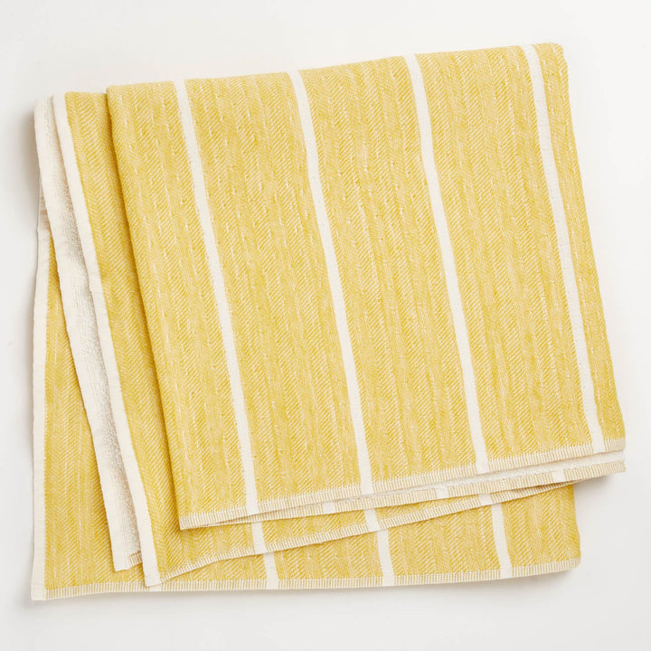 Folded yellow and white striped textile with herringbone texture.