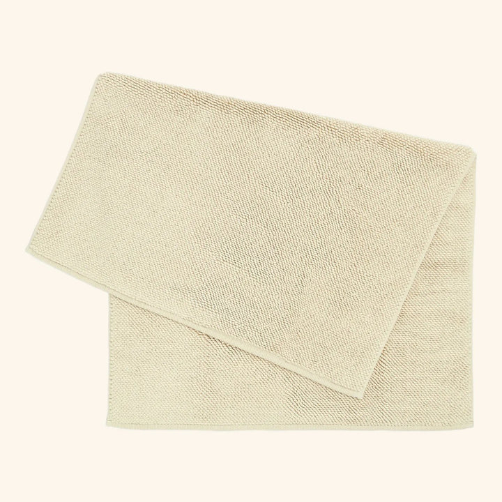 Soft beige towel folded neatly on light background for marketing.