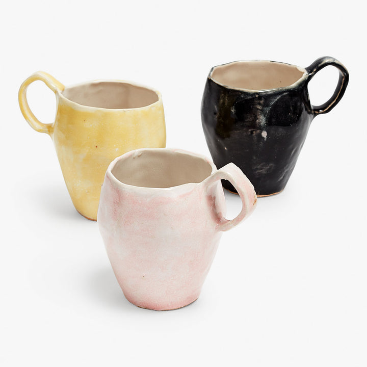 Handcrafted ceramic mugs in yellow, pink, and black sizes