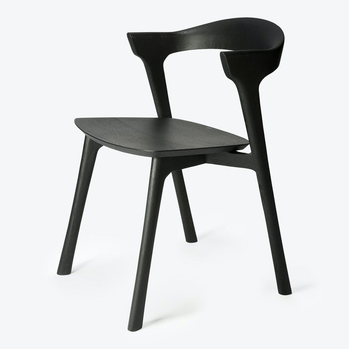 Minimalist black chair with unique silhouette against white background