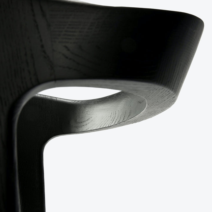 Modern minimalist chair with matte black finish and elegant curves.