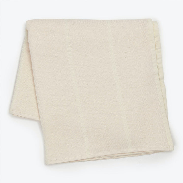 Soft, woven blanket folded neatly on light background, showcasing texture.