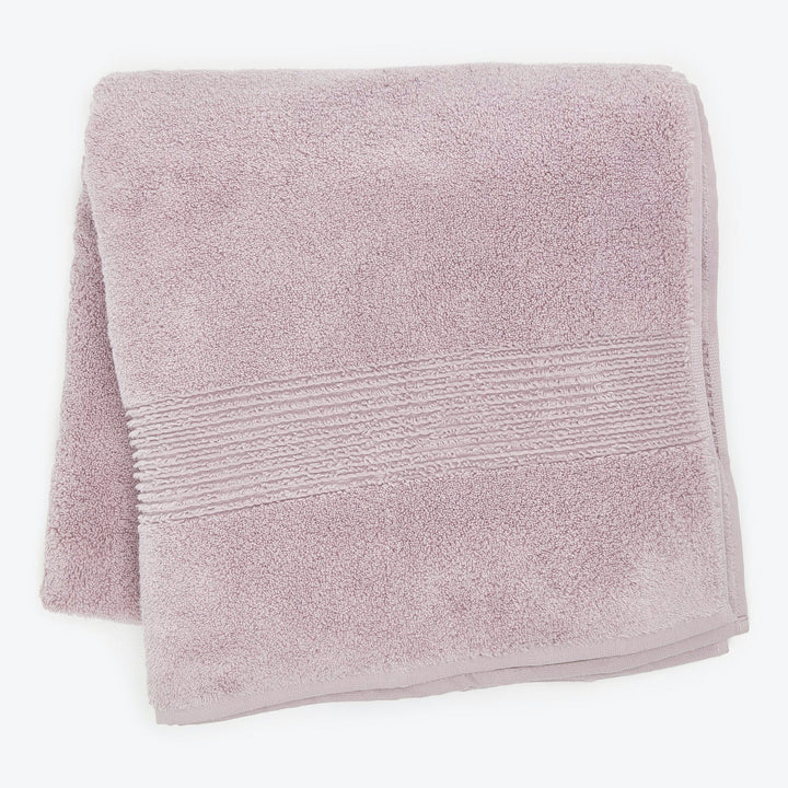 Soft and fluffy light pink towel with decorative band detail.
