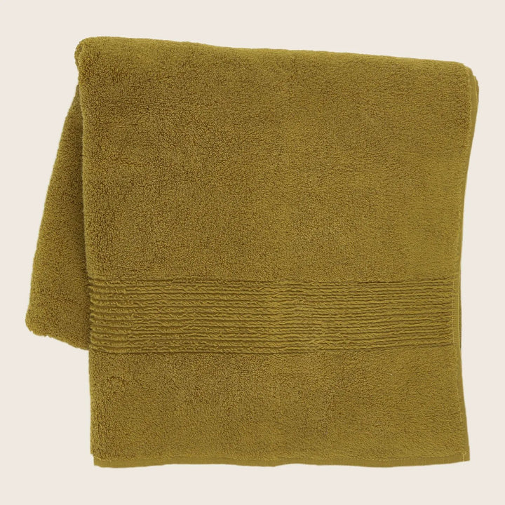 Plush olive green towel with decorative border on light background.