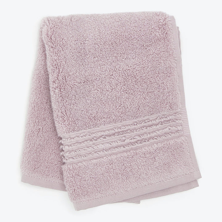 Soft pale pink towel with fluffy texture and decorative border