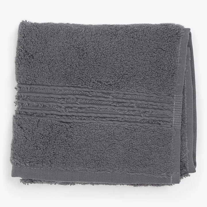 Folded gray terrycloth towel with textured pattern and decorative border.