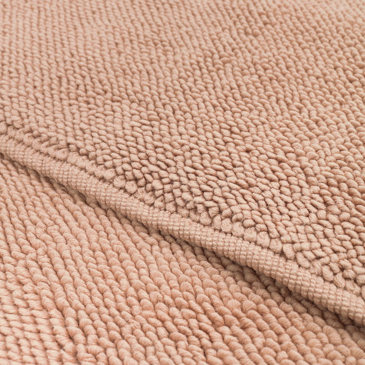 Close-up view of beige loop pile carpet fabric texture.