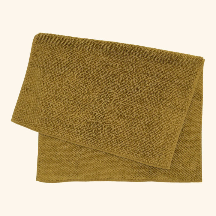 Mustard terrycloth fabric with looped texture folded over itself.