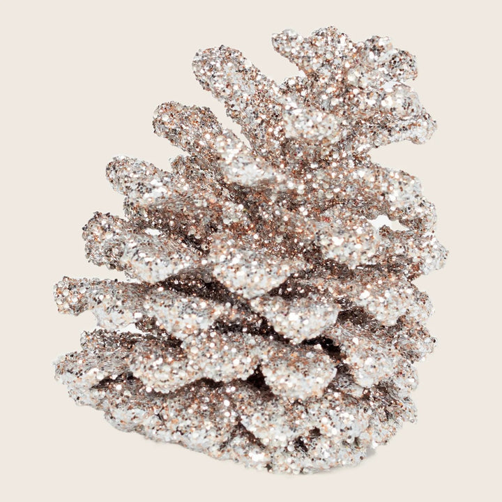 Shiny silver glitter decorates festive pine cone for holiday season.