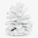 Glitter-coated pinecone sparkles in festive holiday decoration, white background.