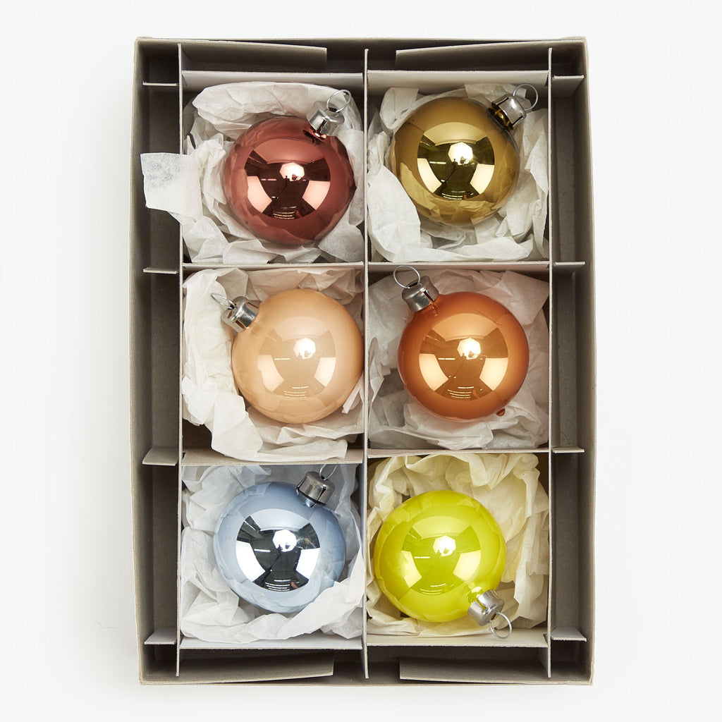 Six colorful glass ornaments in divided cardboard box, organized and protected.