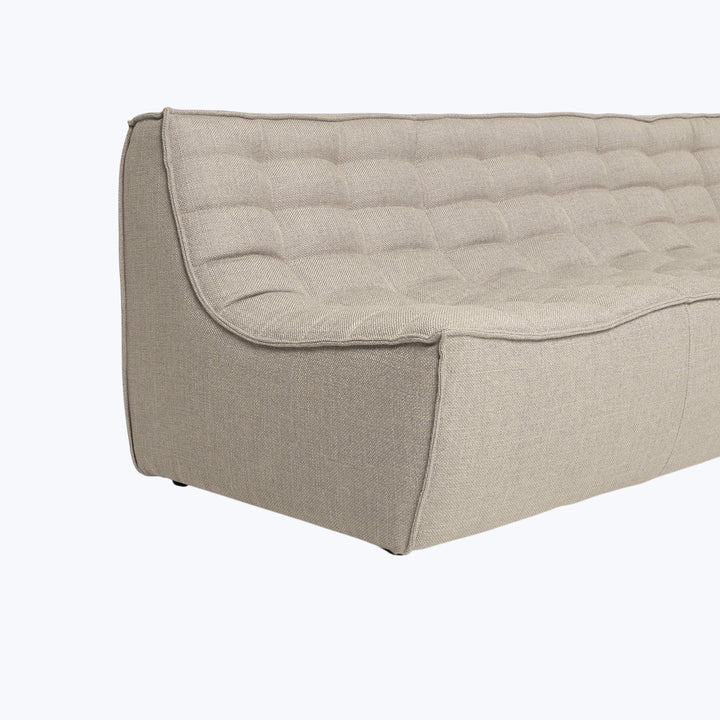Beige tufted fabric sofa with textured weave design, sturdy appearance.
