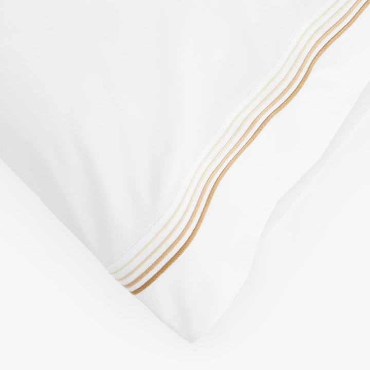 Close-up of white fabric with brown and beige decorative stripes.