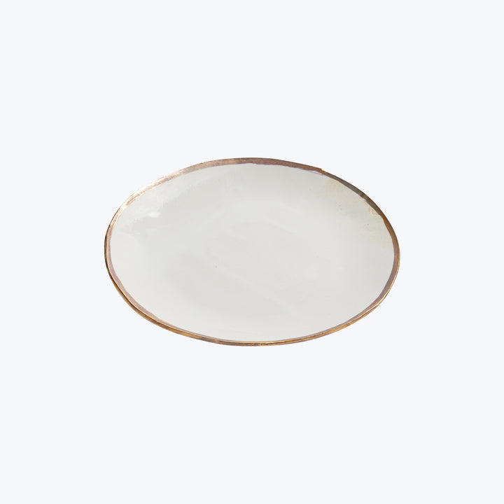 Handcrafted ceramic plate with rustic look and dark rim detail.
